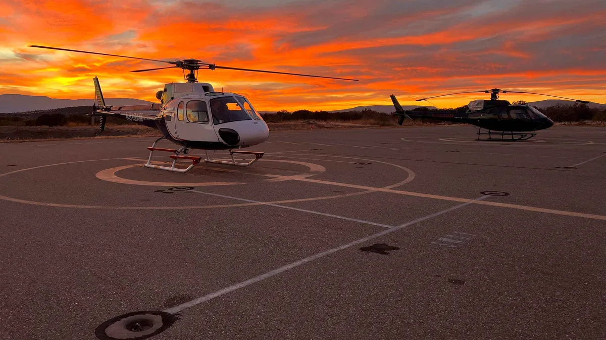 Helicopter flying over red rock wilderness at sunset near Sedona