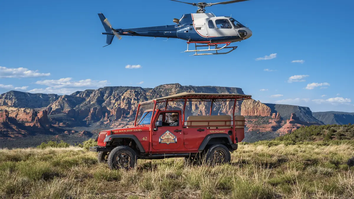 Helicopter and Jeep parked together at a Sedona air-and-land tour meeting point